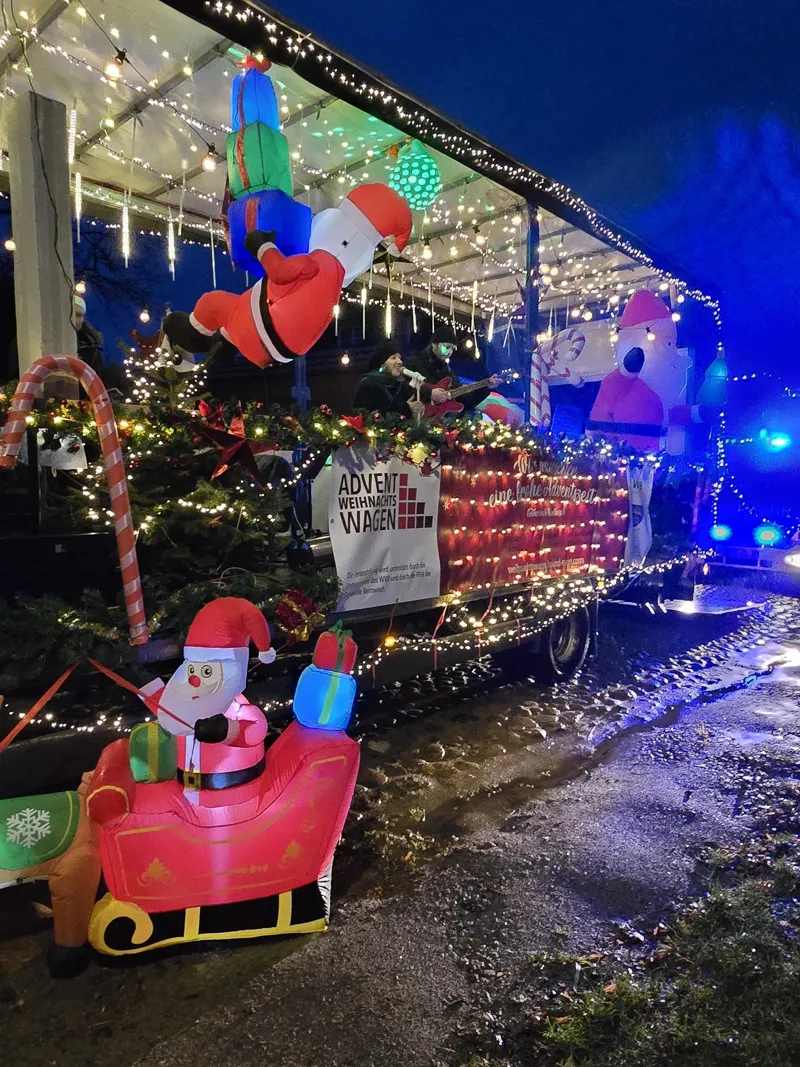 Der beleuchtete Wagen am Abend mit Tannenbaum und Figuren