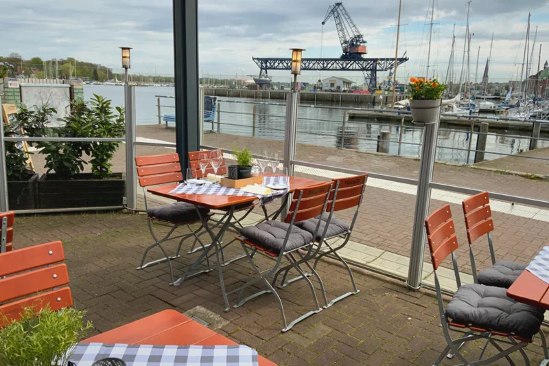 Hafenterrasse des Restaurants CarLo 615 am Warnowufer in Rostock im Abendlicht