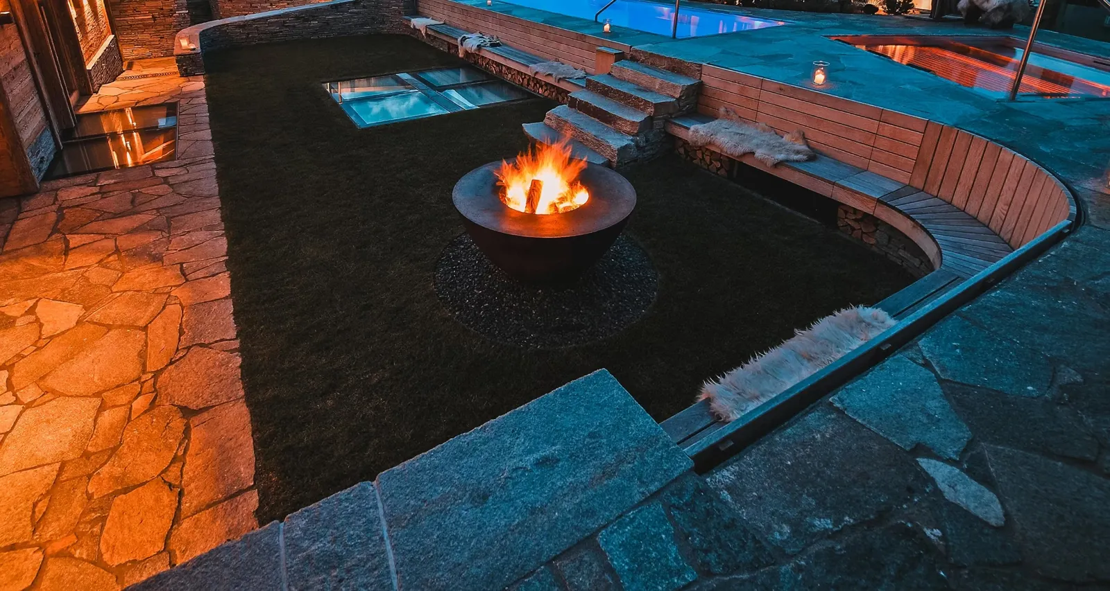 Chalet O am Abend mit Feuerschale