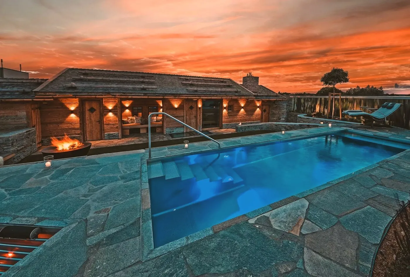 Außenbereich des Chalet O in Rostock mit Pool im Abendlicht