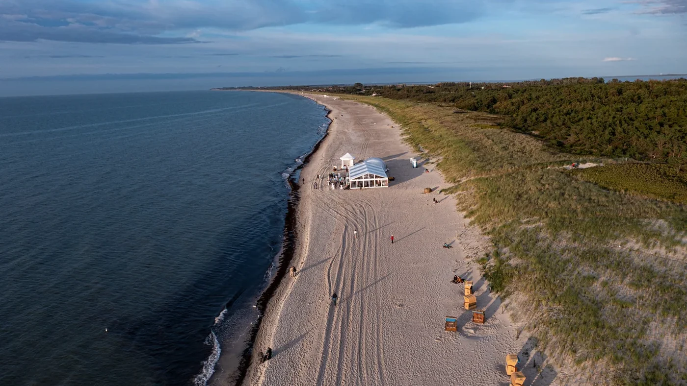 Hochzeitszelt am Ostseestrand aus der Luft, Stuhlreihen und Strandk&ouml;rbe im Sand